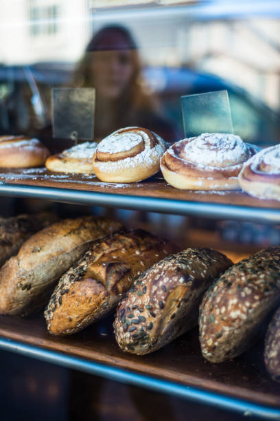 istock Reflection of a Young Woman Admiring Bread in a Bakery Window 1139717624