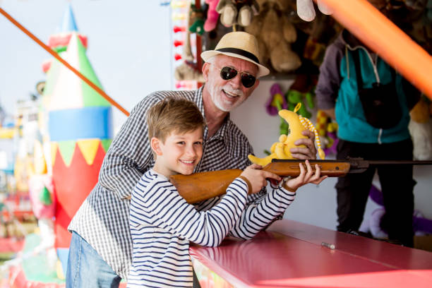 istock Little boy with grandfather having fun at amusement park 1139719607
