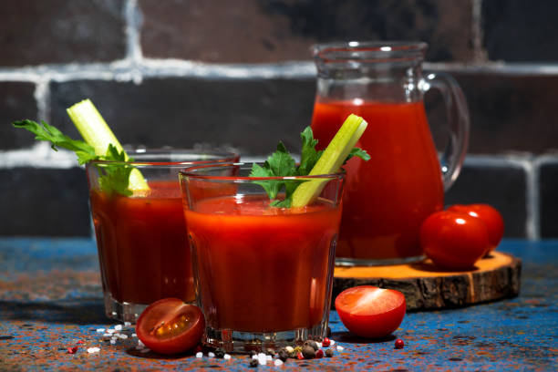 istock fresh tomato juice with salt and celery on dark table, closeup 1139720357