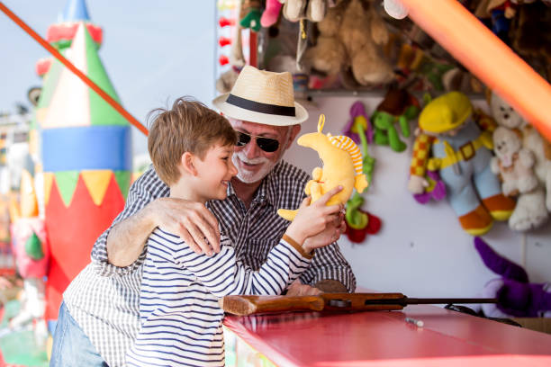 istock Little boy with grandfather having fun at amusement park 1139720396