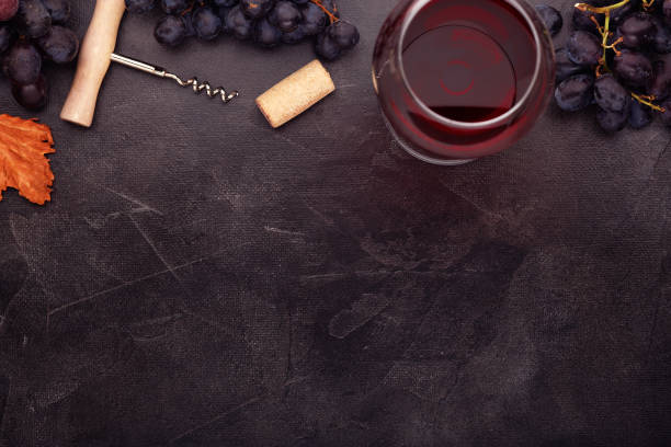 istock red wine and grapes. Wine and grapes in vintage setting with corks on wooden table. Top view 1139720585