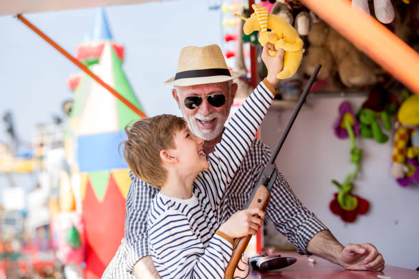 istock Little boy with grandfather having fun at amusement park 1139720681
