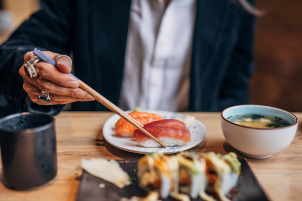 Man eating sushi in sushi bar Mature man eating sushi in sushi bar chinese ethnicity china restaurant eating stock pictures, royalty-free photos & images