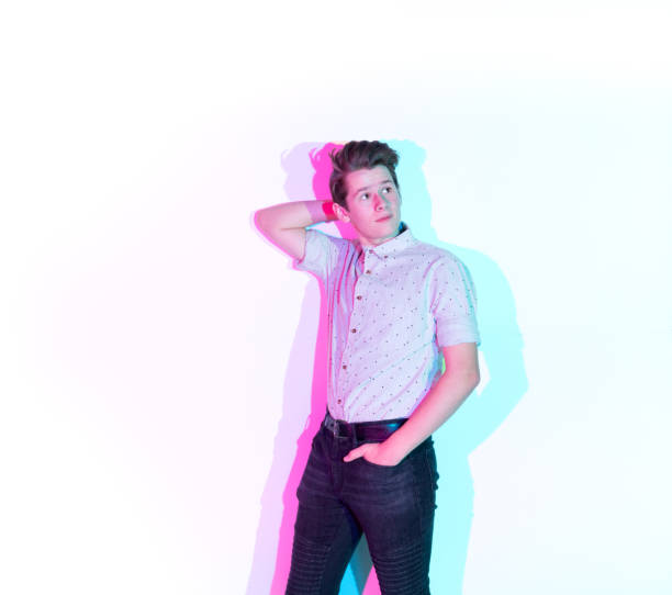 istock Handsome young man standing against white wall with colorful shadows 1139724624