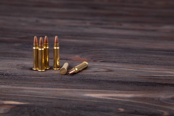 rifle cartridges on a wooden black background - full metal jacket imagens e fotografias de stock