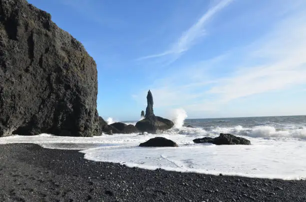 Waves crashing against Reynisdrangar sea stacks in Iceland.