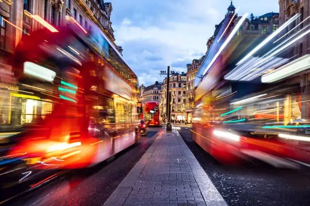 Photo of London typical red bus blurred motion at night in Oxford Circus