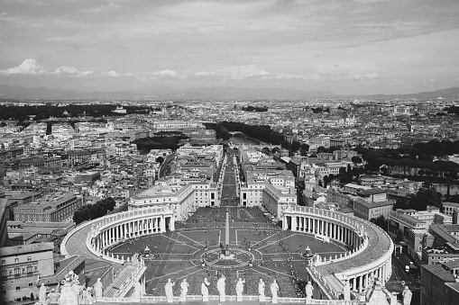 Rome, Italy - June 22, 2018: Panoramic view on the St. Peter's Square and city of Rome from Papal Basilica of St. Peter (St. Peter's Basilica). Summer day and people walk on square
