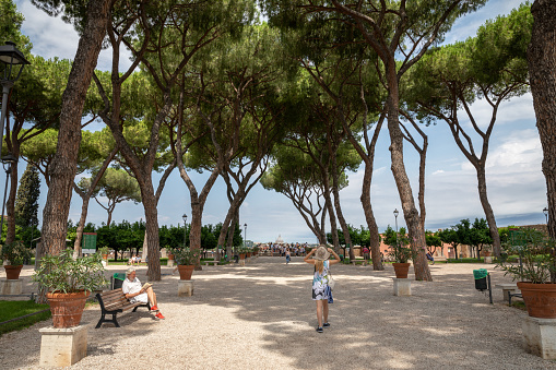Rome, Italy - June 23, 2018: Panoramic view of Orange Garden (Giardino degli Aranci) on Aventino Hill. People walk and rest in national park of Rome. Summer day and blue sky