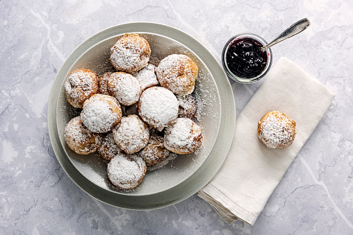 Traditional apple slices or Æbleskiver in danish. Their name does not really describe them very well. They are ball shaped dough with a pancake like texture. A piece of apple or prune can be added to the middle of the dough halfway through cooking although this is optional, they are usually eaten with jam. Colour, horizontal with some copy space.