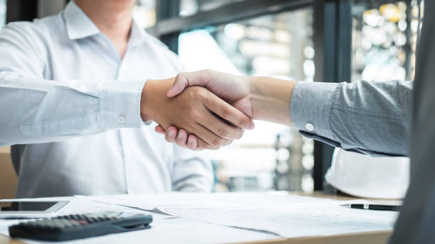 istock Handshake of collaboration, Construction engineering or architect discuss a blueprint and building model while checking information on sketching, meeting for architectural project of partner 1139733095