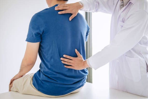 istock Doctor physiotherapist treating lower back pain patient after while giving exercising treatment on stretching in the clinic, Rehabilitation physiotherapy concept 1139733206