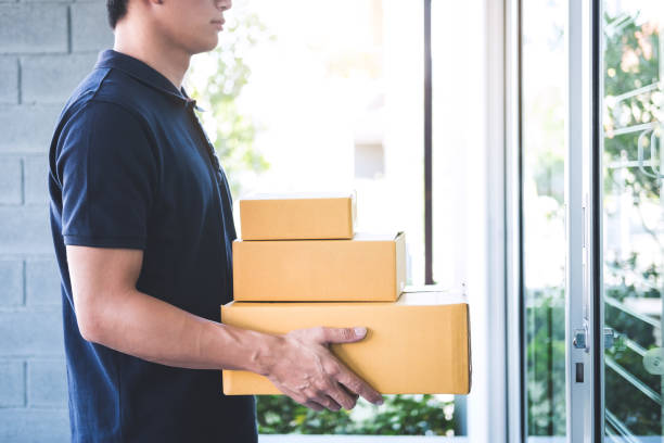 istock Delivery man standing with parcels in hands outdoors waiting homeowner open door, Home delivery service and working with service mind 1139733285