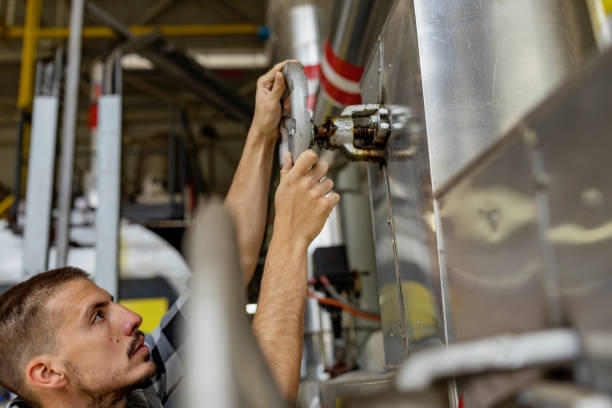 istock Young Technician is Inspecting Heating System in Boiler Room 1139734304