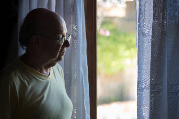 istock Senior man wearing eyeglasses looking through window 1139737197
