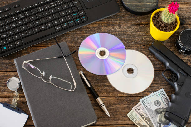 istock Ofiice table with headgun and office materials at the rustic table with us paper currency ( mobbing ) 1139740532