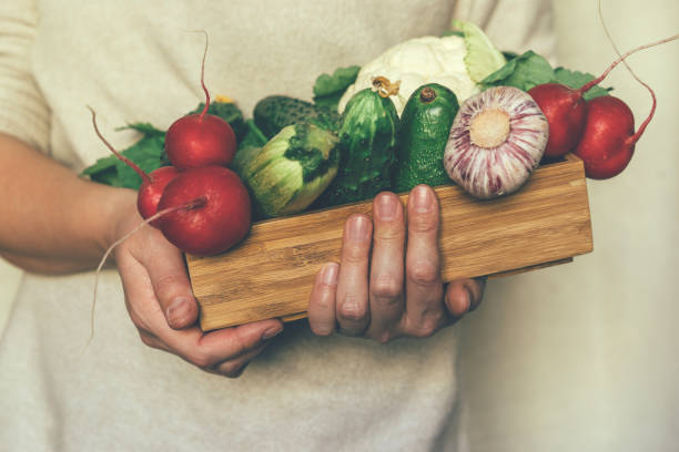 istock vegetables in a wooden box in the hands 1139741732
