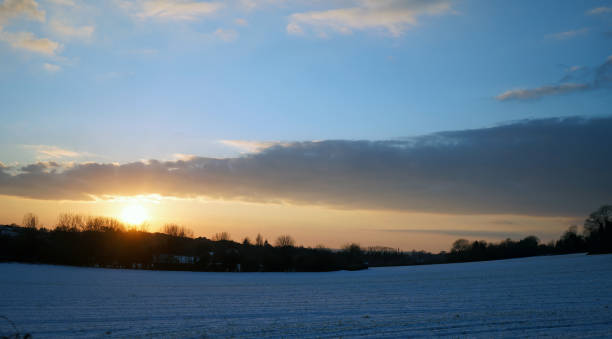istock Sunset over a snow covered farm field 1139743038