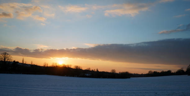istock Sunset over a snow covered farm field 1139743087