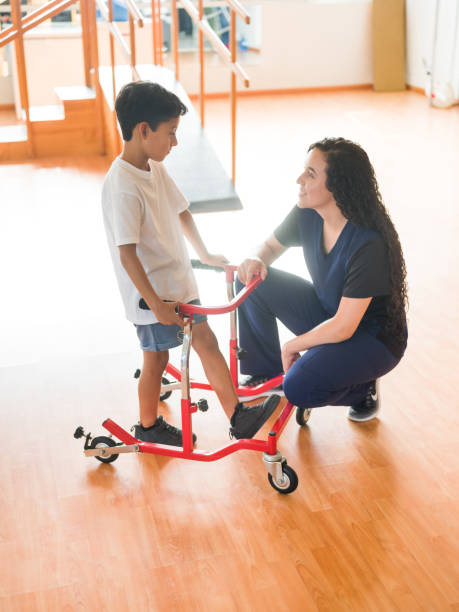 istock Little boy holding frame walking during physical therapy 1139743282