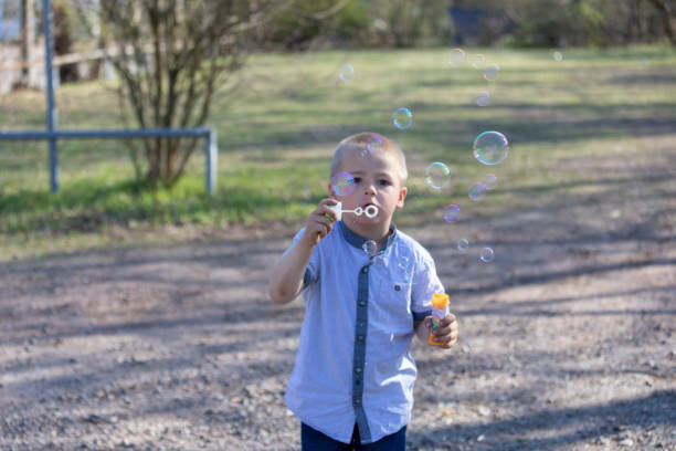 istock Little boy blowing soap bubbles, closeup portrait 1139744453