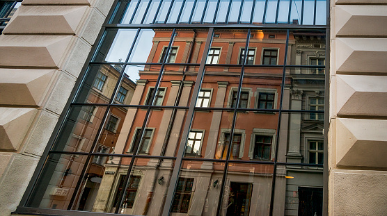 Housing with historic elements, straight lines and wooden windows. Next to historic building is apartment building with completely different style of architecture,It forms imaginary period boundary.