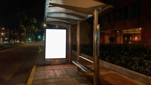 Blank billboard in bus stop at night stock photo
