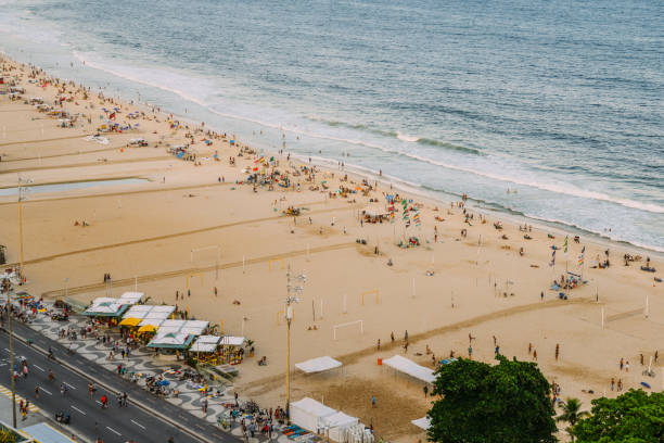 opinião superior aérea os povos que relaxam na praia de copacabana em rio de janeiro, brasil - beach kiosk above - fotografias e filmes do acervo
