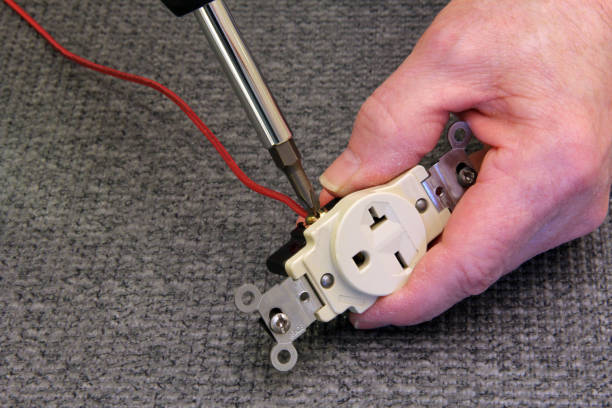 istock Electrician attaching a wire to an electrical outlet 1139756998