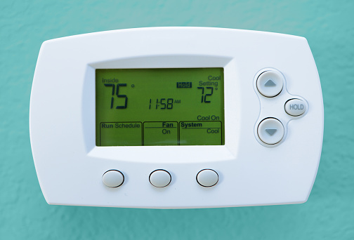 Digital thermostat showing time and temperature in degrees Fahrenheit