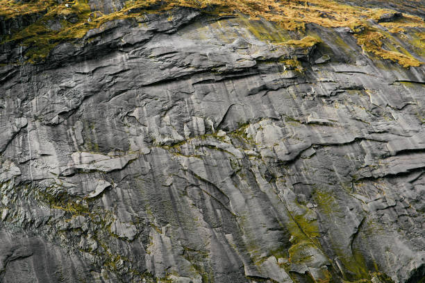 istock Massive structured steep stone wall with green gras and moss in the mountains on the Lofoten Islands in Norway. 1139761430