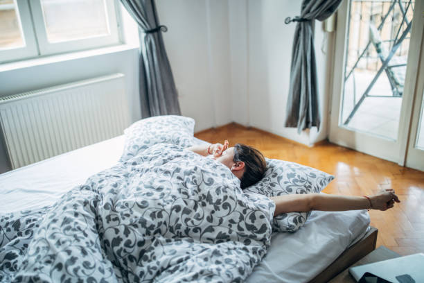istock Sleepy woman is stretching in the bed 1139767350