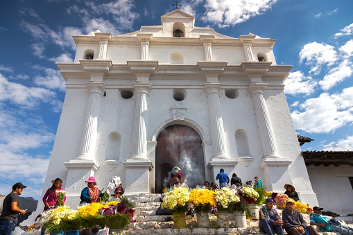 Chichicastenango, Guatemala - January 4, 2019: Local Guatemalan People Burning Incense and Selling Yellow Flowers in Front of Iglesia De Santo Tomas on a Market Day