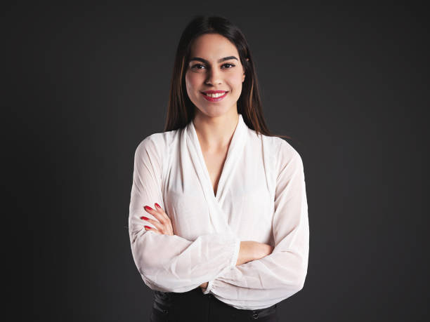 istock Smiling woman standing with arms crossed 1139774622