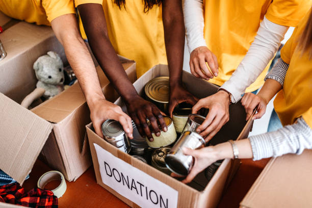 We are feeling proud when helping other people African American woman and her colleague working in homeless shelter canned food stock pictures, royalty-free photos & images