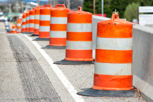 Traffic Barrels With Shallow Depth of Field Horizontal close-up shot of orange and white striped traffic barrels down the side of a road with shallow depth of field. traffic cone photos stock pictures, royalty-free photos & images