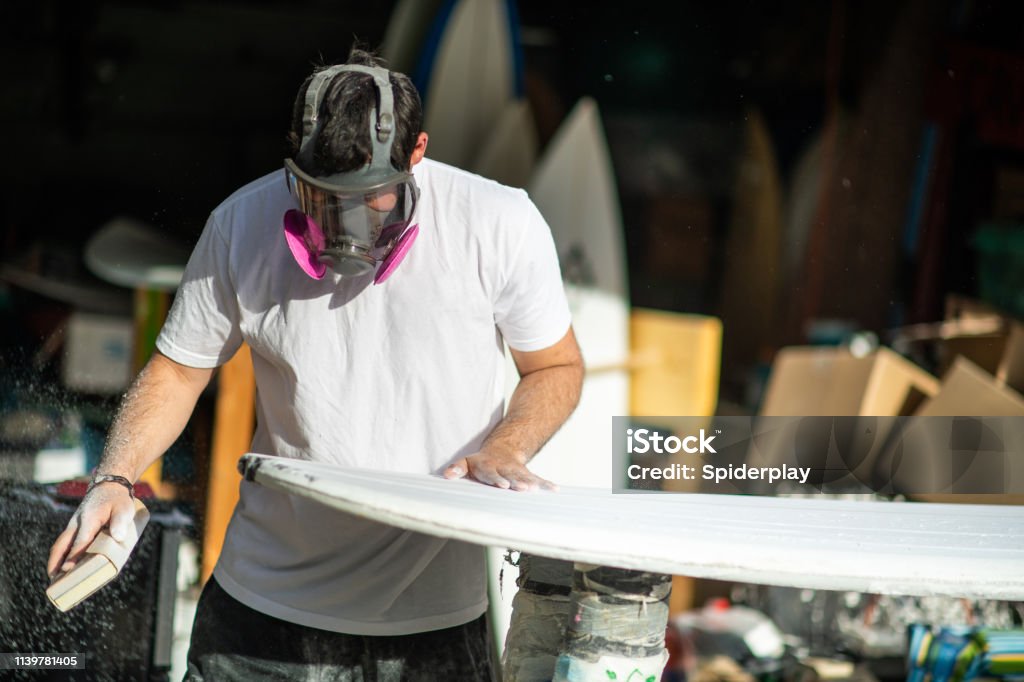 Unga entreprenör crafting en anpassad surfbräda - Royaltyfri Mall Bildbanksbilder