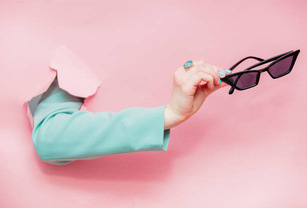 istock Female hand in classic blue jacket with sunglasses looks 1139781499