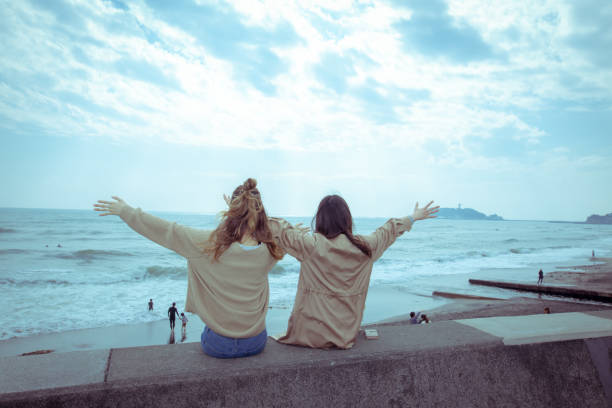 jovencitas amigas refrescantes en la playa - kamakura japan tourist people fotografías e imágenes de stock