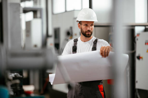istock Engineer with blueprint in factory 1139783367