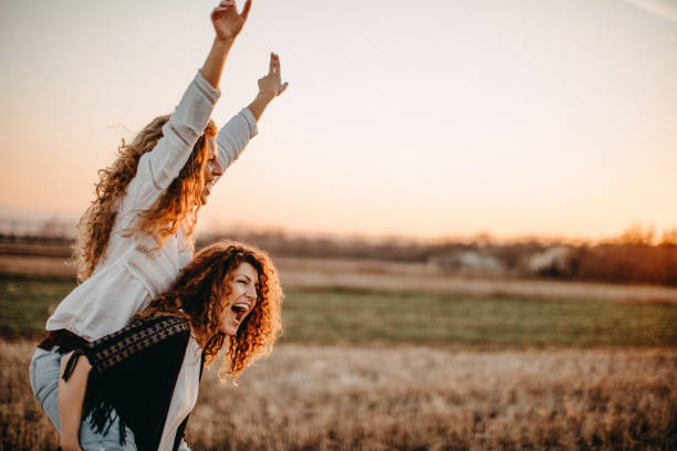 Two beautiful women having fun in meadow