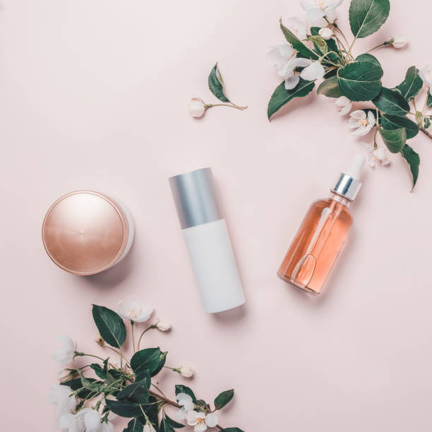 Pink natural cosmetics: oil, serum, cream, mask on background with flowers. Flat lay, minimalism. Pink natural cosmetics: oil, serum, cream, mask on the background with flowers. Flat lay, minimalism apple tree photos stock pictures, royalty-free photos & images