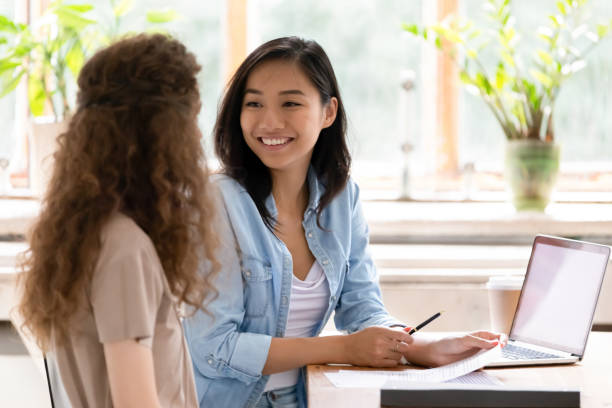 Smiling asian hr insurer advisor meeting applicant at job interview Smiling asian hr insurer advisor meeting applicant at job interview consulting client about contract offer giving advice, happy diverse girls colleagues interns students discussing paperwork together asian property stock pictures, royalty-free photos & images