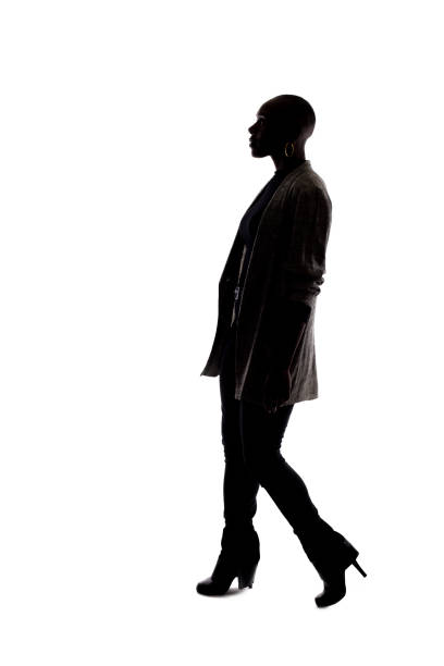 istock Silhouette of a Black Female Model on a White Background Walking 1139791164