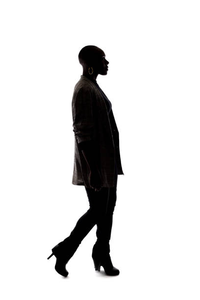 istock Silhouette of a Black Female Model on a White Background Walking 1139791177