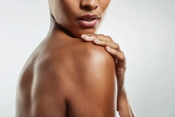 Studio shot of an attractive young woman posing against a grey background