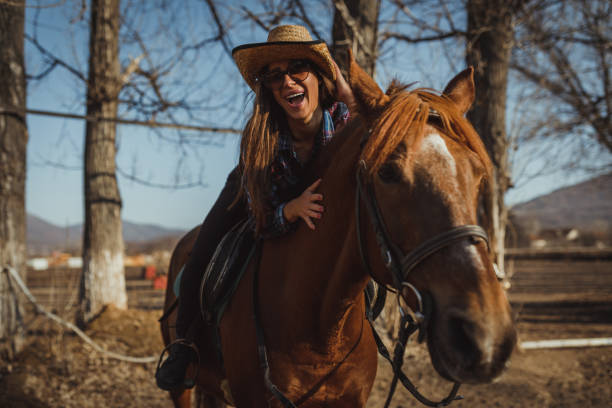 Smiling young woman enjoying horseback riding on a sunny day