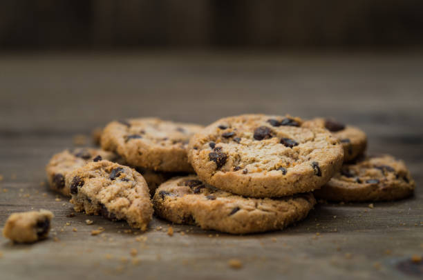 classici biscotti al cioccolato su sfondo ligneo. concetto di dessert, cottura al forno e cibo dolce - quick cookies foto e immagini stock