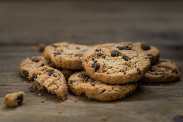 classici biscotti al cioccolato su sfondo ligneo. concetto di dessert, cottura al forno e cibo dolce - quick cookies foto e immagini stock