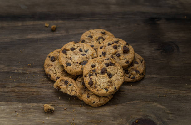 classici biscotti al cioccolato su sfondo ligneo. concetto di dessert, cottura al forno e cibo dolce - quick cookies foto e immagini stock